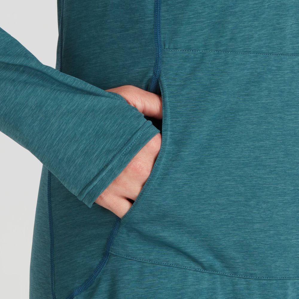 Someone wearing a teal NRS Silkweight Hoodie Dress, crafted with recycled materials for UV protection, places their hand in the front pocket.
