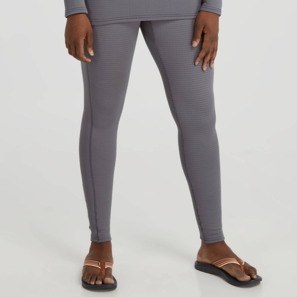 A person wearing NRS Lightweight Pants for women, featuring moisture-wicking properties, and black sandals stands against a plain background.
