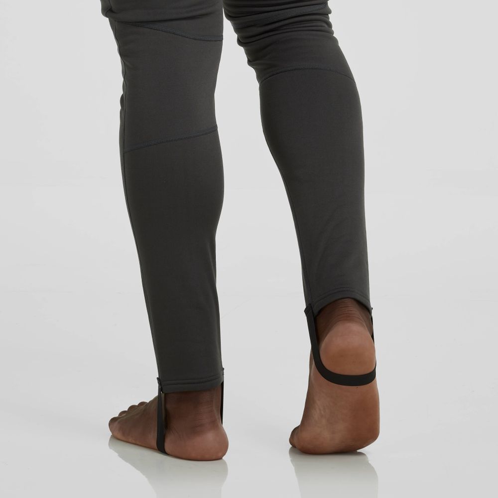 Standing barefoot on a smooth, reflective surface, the person showcases the Expedition Weight Union Suit by NRS—men's dark gray attire crafted from recycled materials for those valuing style and sustainability.