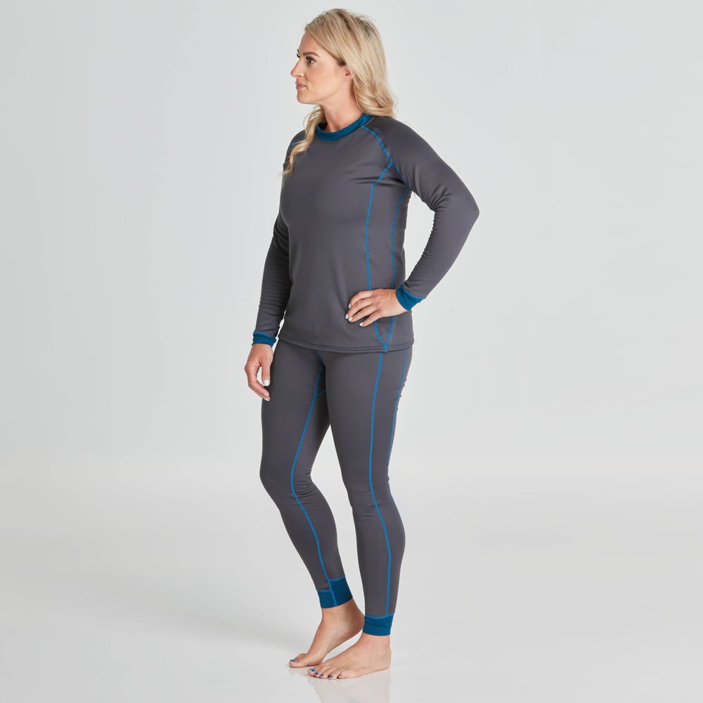 A person stands in profile wearing the NRS Expedition Fleece for women, featuring a long-sleeve gray top and matching leggings with blue seams, made from recycled materials, set against a plain background.