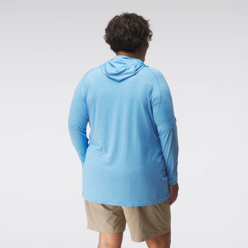 An individual in a blue NRS Silkweight Hoodie for women and beige shorts, facing away. This breathable outfit provides sun protection, ideal for adventurous outings.