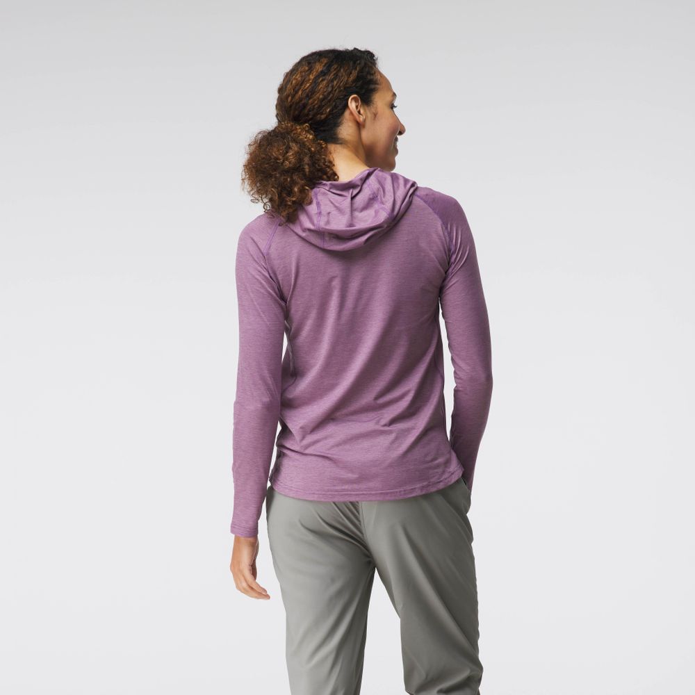 A person with curly hair in an NRS Silkweight Hoodie - Women's in purple and gray pants stands side-view against a plain background. The hoodie's technical fabric offers excellent sun protection.