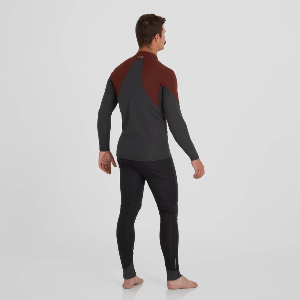 A person stands barefoot in a two-tone wetsuit, gazing sideways. The maroon and dark gray suit has long sleeves and insulating pants, similar to the NRS Hydroskin 0.5mm Pants - Men's. The plain white background highlights the sleek design.