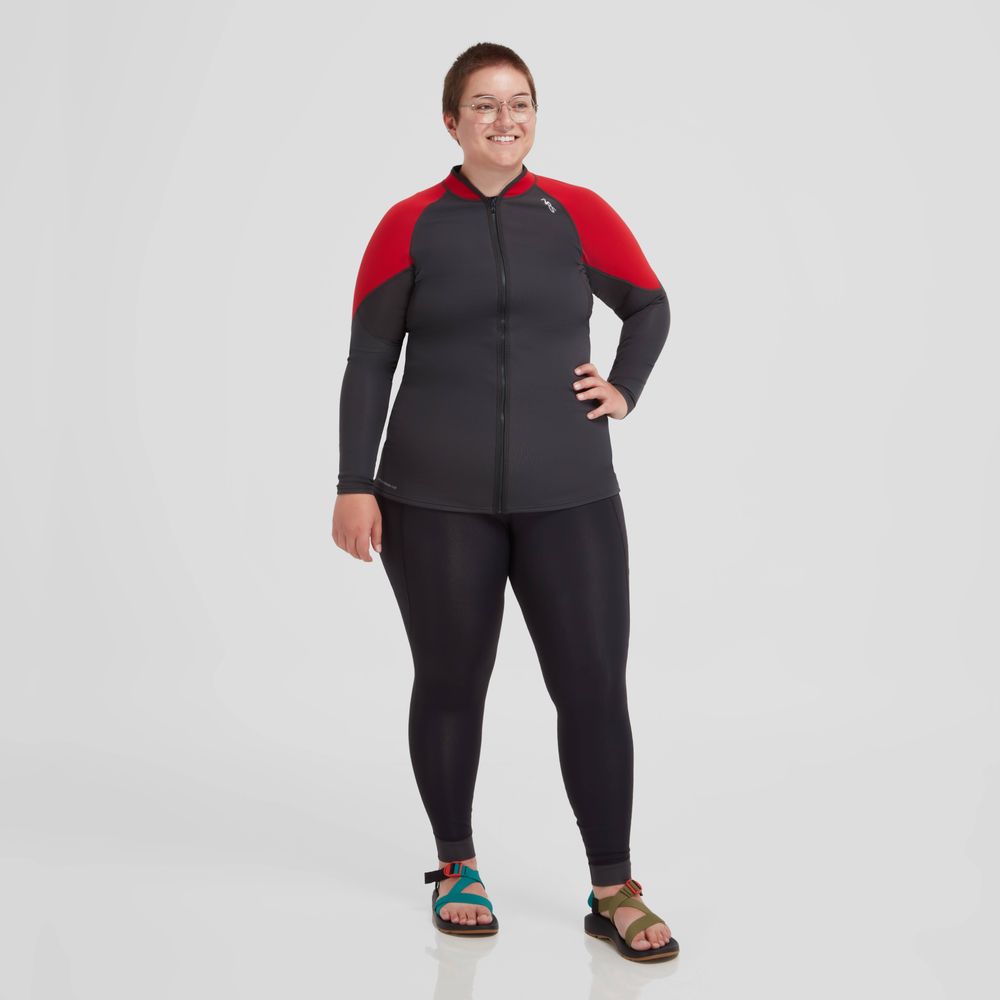 A person in a black and red NRS Hydroskin 0.5mm Pant - Women's wetsuit, providing light insulation, stands confidently against a plain white background.