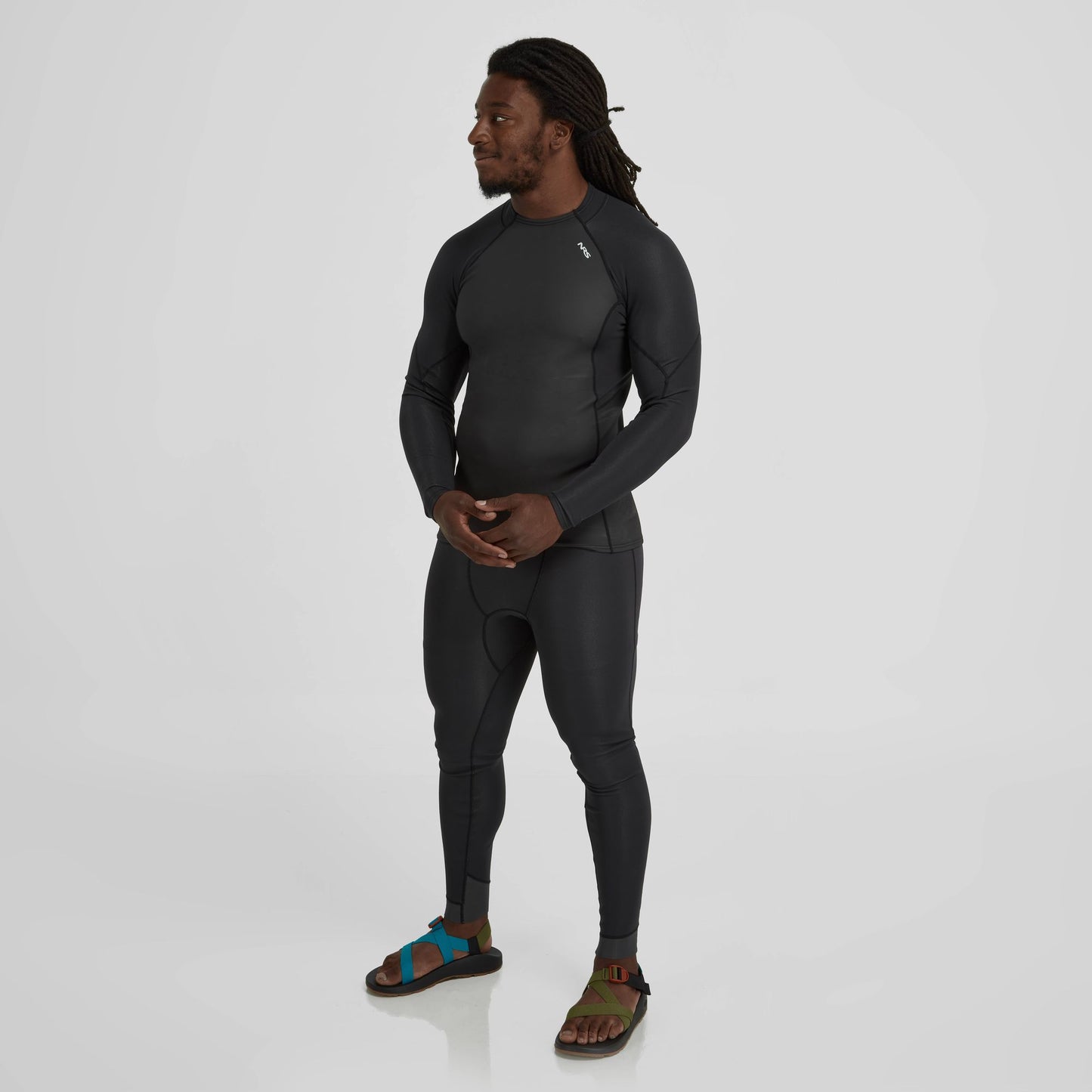 A man wearing an NRS Hydroskin 1.0 Long Sleeve Shirt - Men's to stay warm in the cold water.