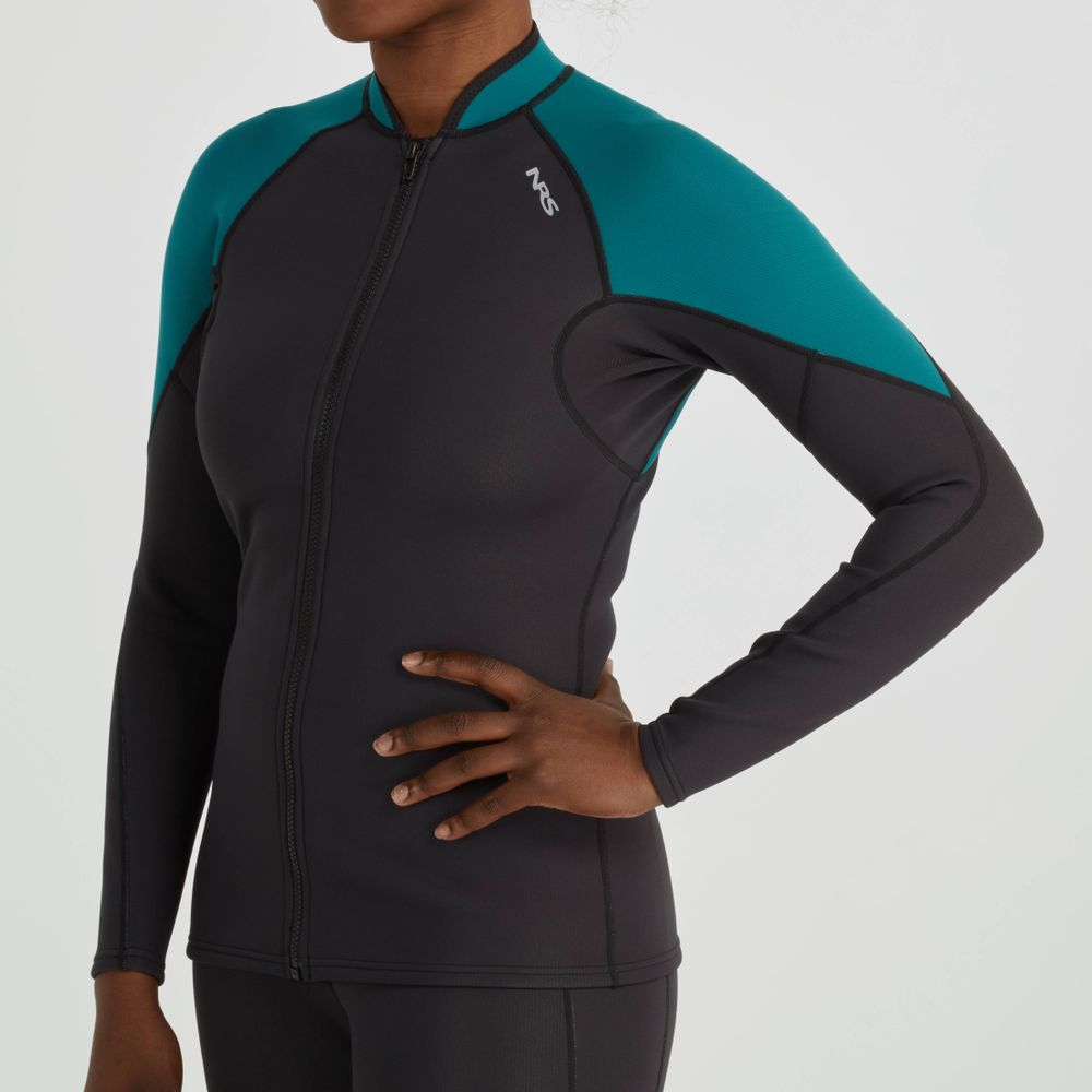 A person stands confidently against a plain background, hands on hips, wearing the NRS Women's Hydroskin 1.5mm Jacket. This black and teal long-sleeve wetsuit enhances paddling performance with excellent neoprene insulation for warmth and flexibility.
