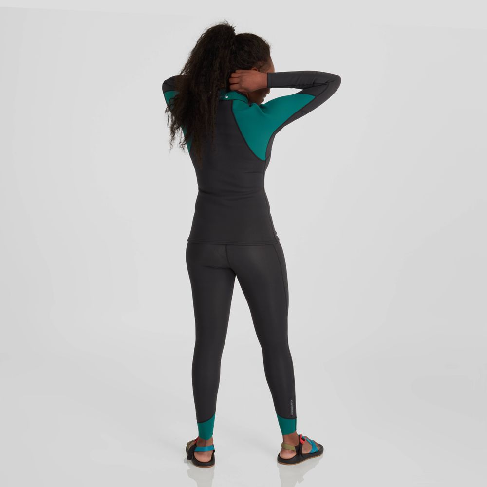 A person in a black and teal wetsuit adjusts their hair, poised to test the paddling performance of their NRS Hydroskin 1.5mm Pants - Women's, as they stand against a plain, light background.