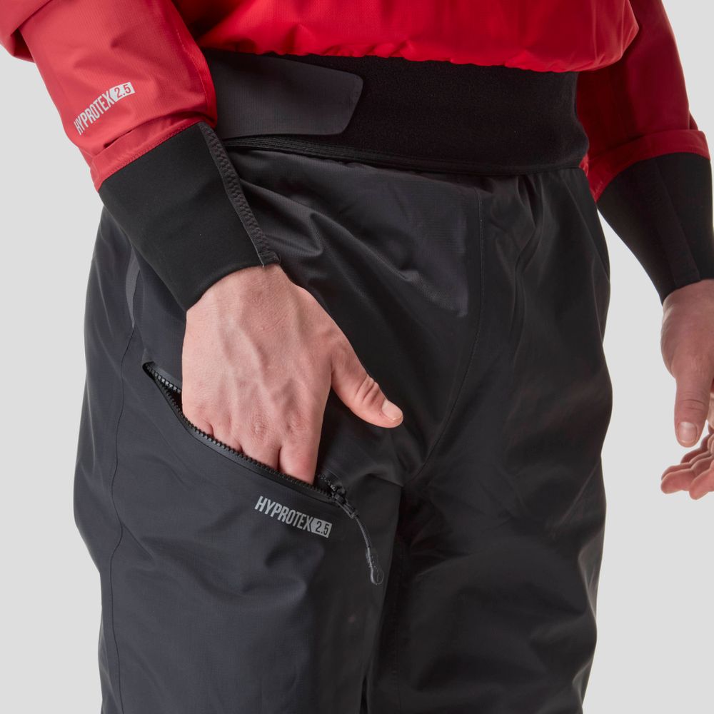 A person wearing NRS's Endurance Splash Pant - Men's, crafted from breathable HyproTex fabric in red and black, has their hand in a zippered pocket labeled "HyproTex.