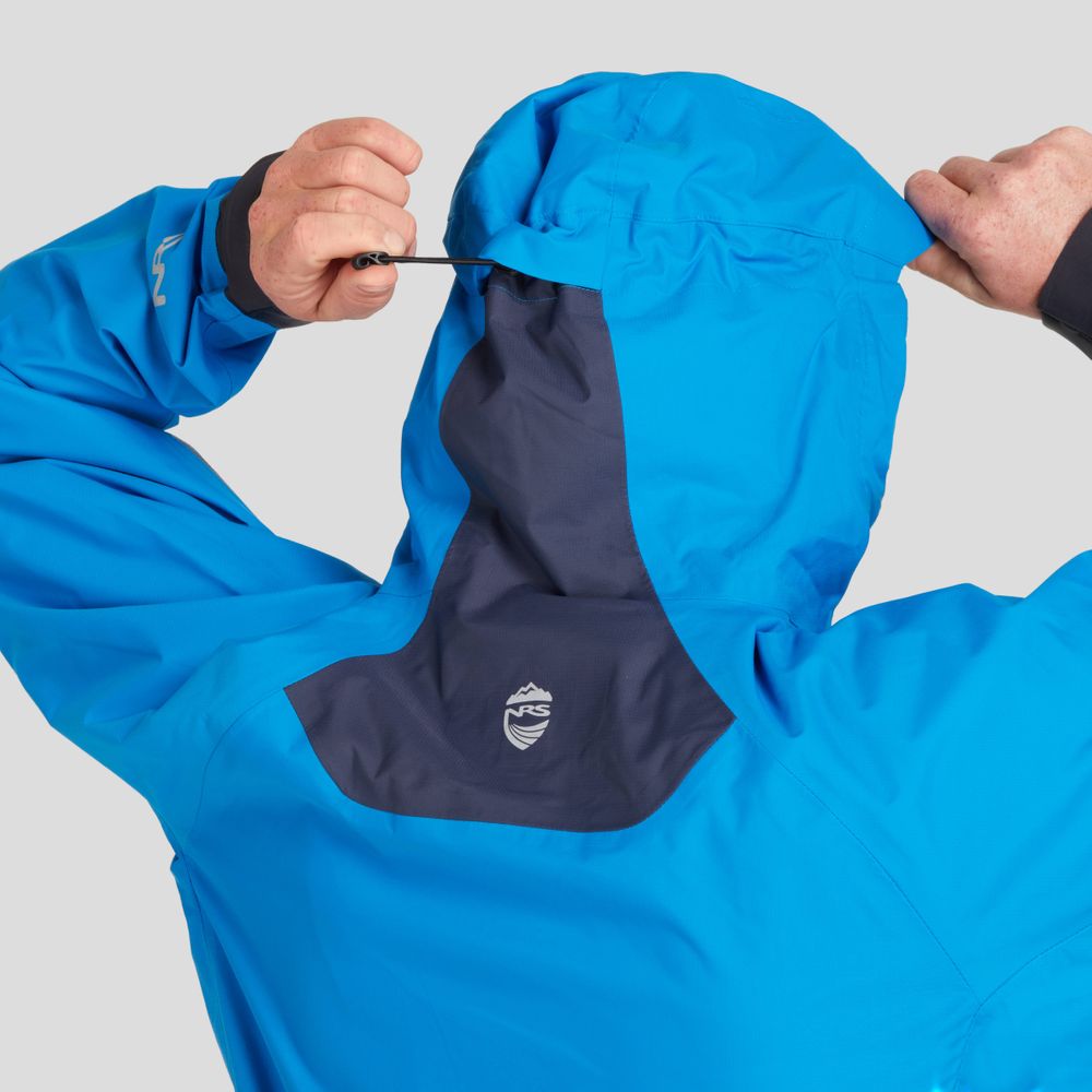 A person adjusts the hood of a blue and navy High Tide Jacket for men by NRS, showcasing the logo on its back against a plain background.