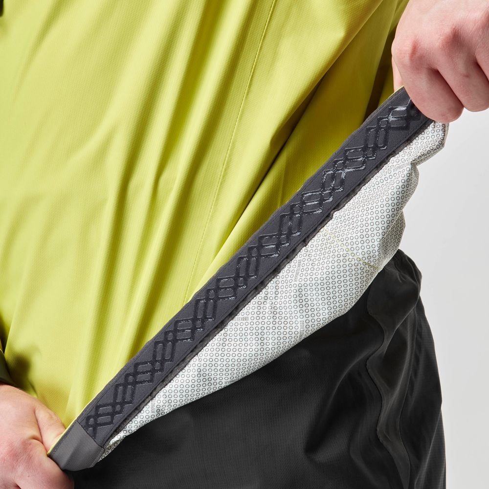 A person showcases the interior grip and fabric texture of the NRS High Tide Jacket - Men's, demonstrating its waterproof breathable lining and adjustable hood for added comfort.