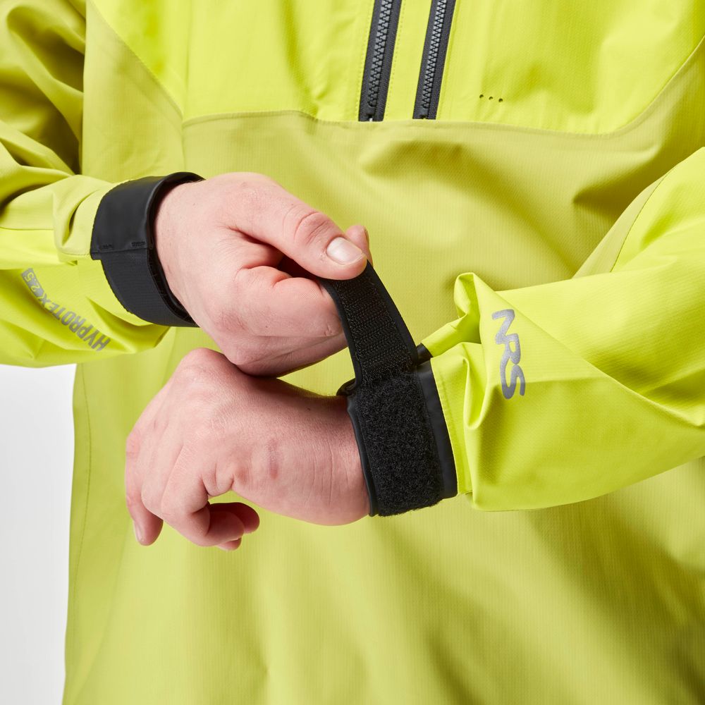 A person adjusts the Velcro strap on a vibrant yellow NRS High Tide Jacket for men, crafted for paddling protection.