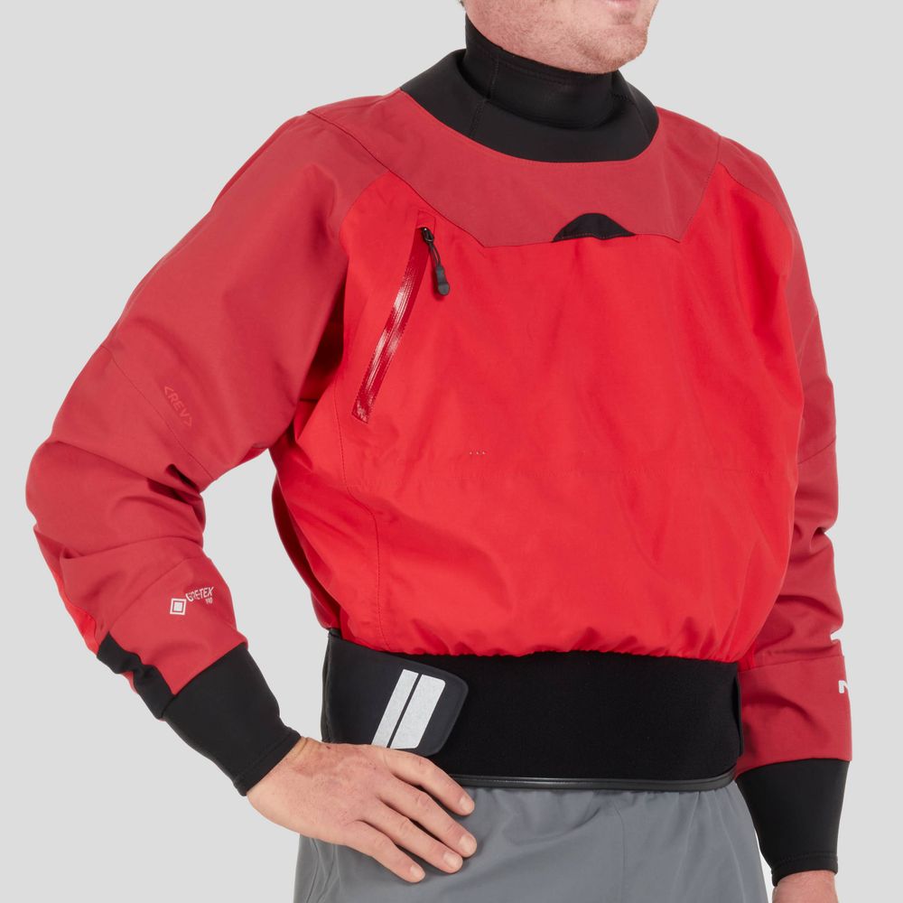 A person wearing the NRS REV Drytop in red, featuring a chest zippered pocket, black cuffs, and waistband. Designed for top paddling performance, it uses GORE-TEX Pro material for durability in tough conditions.