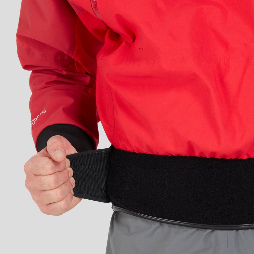 A person skillfully adjusts the black waistband on a red and gray NRS REV (GORE-TEX Pro) Drytop, focusing on optimizing their paddling performance.
