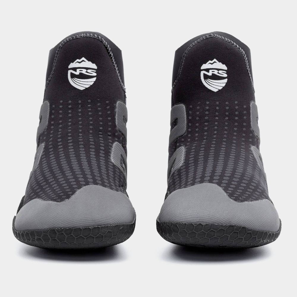 Black and gray NRS Freestyle WetShoe water shoes feature minimalist rubber soles, textured surfaces, and white logos on the upper front.
