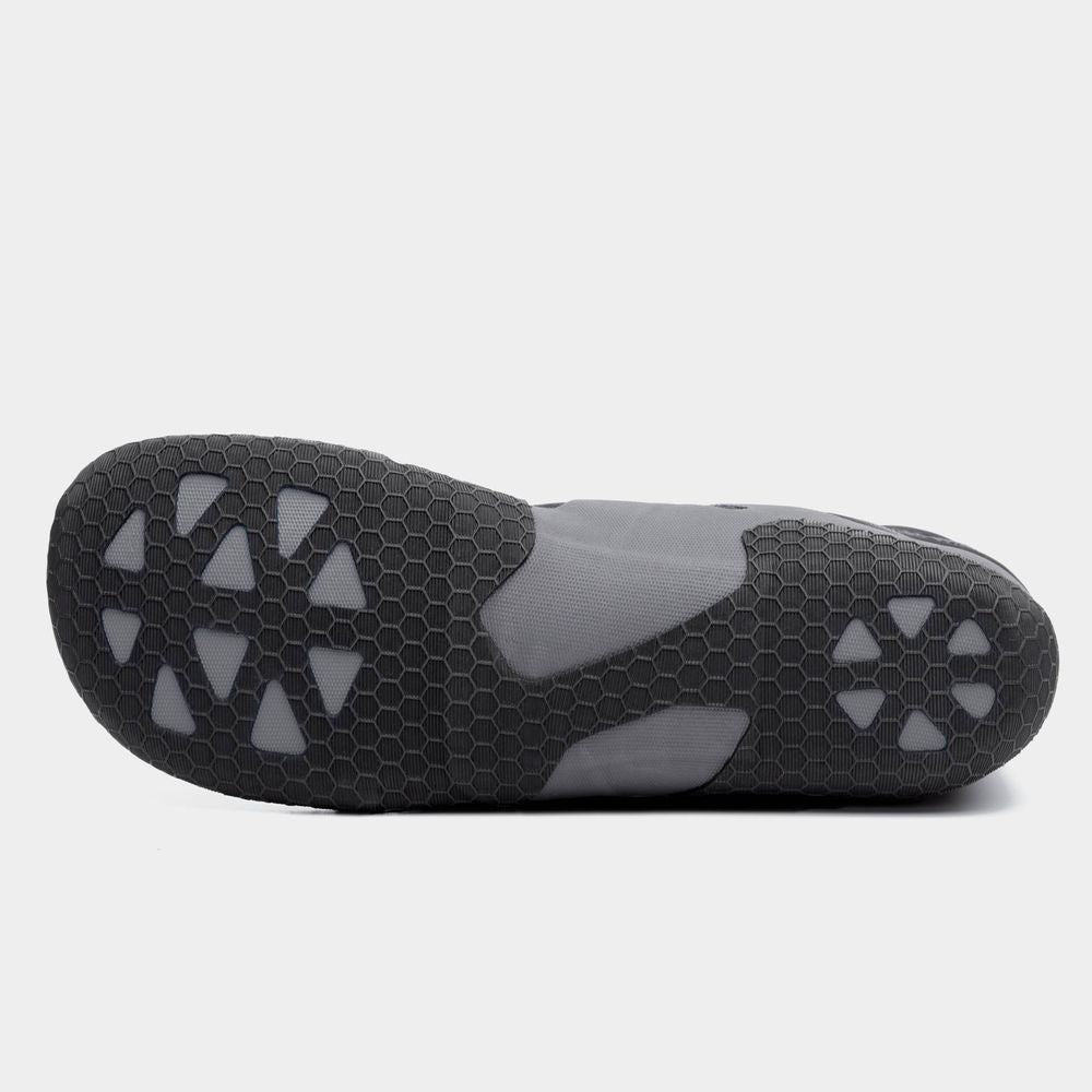 The image displays the sole of the NRS Freestyle WetShoe, highlighting its minimalist rubber design with hexagonal and triangular patterns on a gray background.