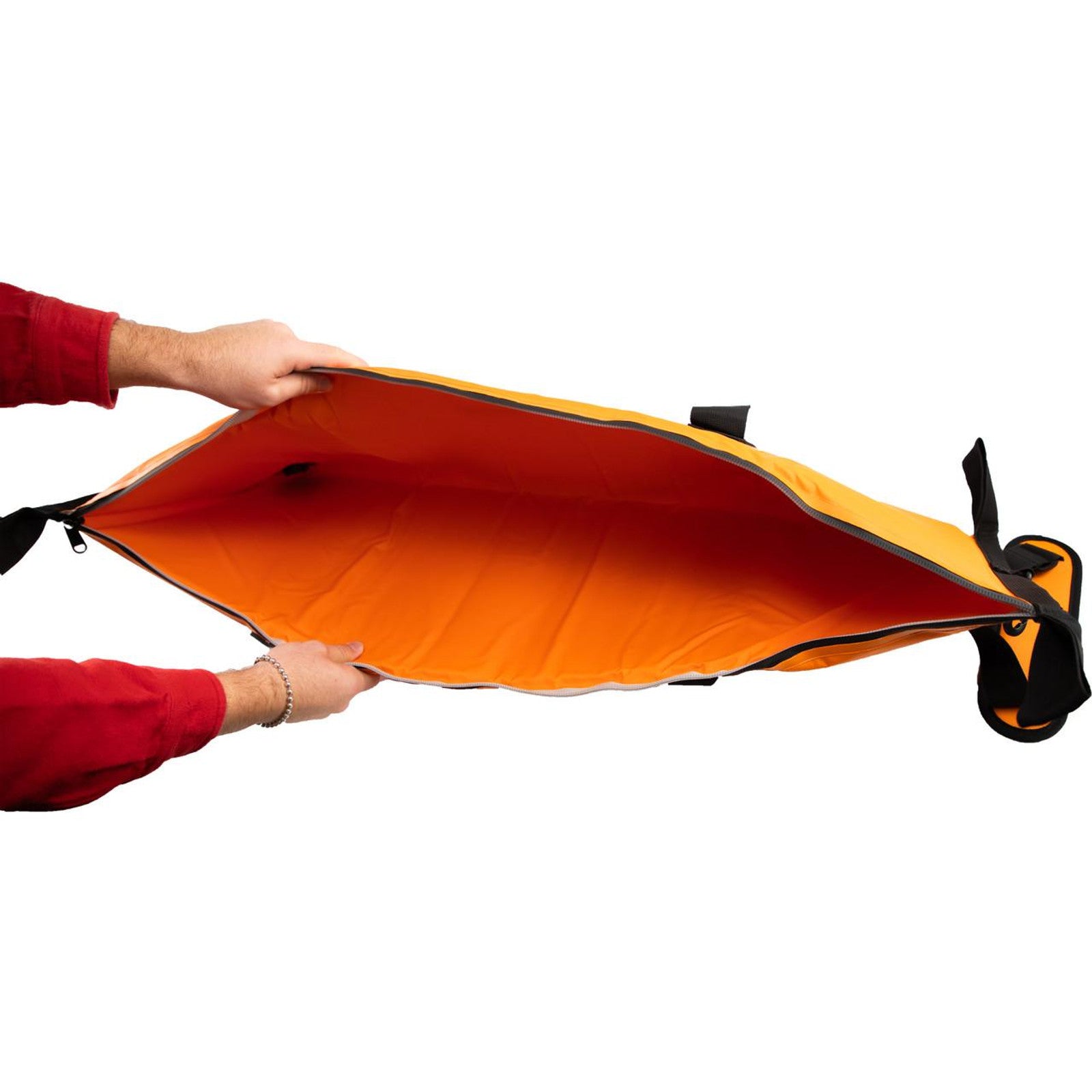 Two hands hold open an empty, bright orange and black YakAttack Insulated Fish Cooler Bag with a zipper, viewed from above on a white background.