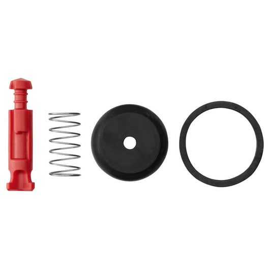 Components from the Leafield D7 Repair Kit, including a red plastic piece, metal spring, black circular item with a hole, and valve cap o-ring, are lined up in a row.