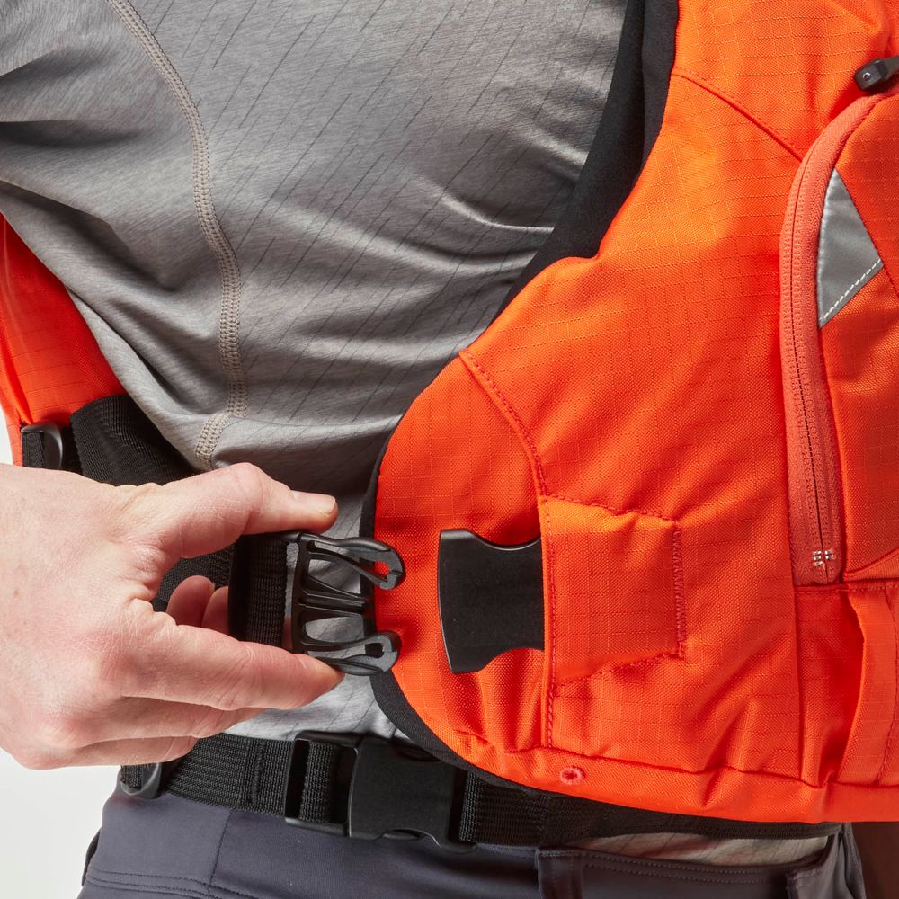 Fastening a black buckle on an orange safety vest perfectly embodies the sleek design of the NRS Ninja PFD, offering excellent flotation in a compact package tailored for paddlers seeking top performance.