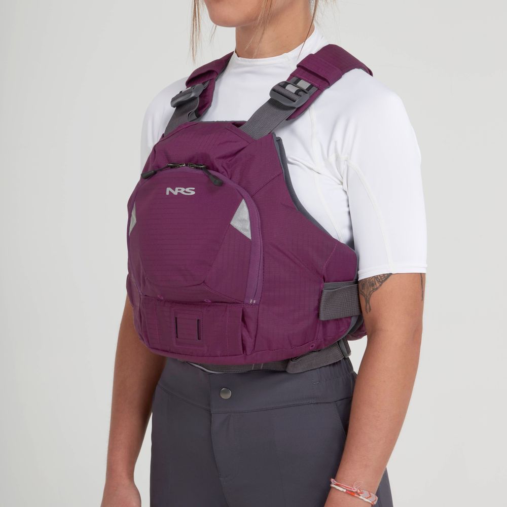 An individual wearing an NRS Ninja PFD in maroon over a white shirt and dark pants stands slightly sideways against a plain background.