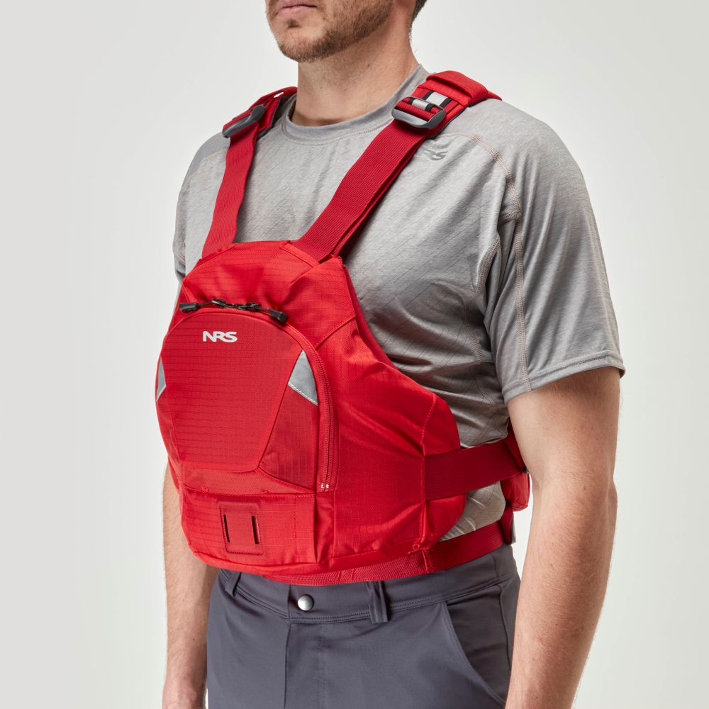 A person in a gray shirt wears a red NRS Ninja PFD, known for its compact flotation design.