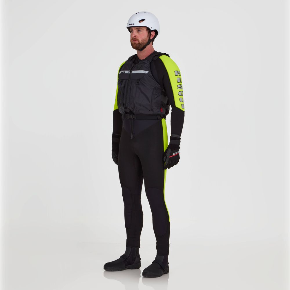 A person models the NRS Big Water Guide Hi-Float wetsuit in black and neon yellow, paired with black gloves and a white helmet, highlighted by reflective tape for better visibility, against a plain white background.