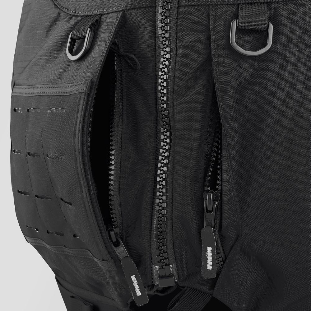 Close-up of the NRS Big Water Guide Hi-Float backpack in black, showcasing two zippers, metal loops, and a textured fabric with stitched patterns. It includes customizable accessories for versatility.