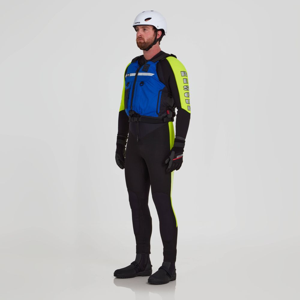 A man is wearing the NRS Big Water Guide Hi-Float gear, which includes a blue and neon yellow wetsuit, helmet, gloves, and black boots, all featuring SOLAS reflective tape for safety. He stands against a plain white background.