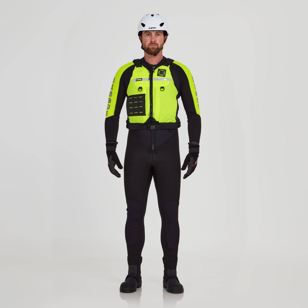 A person in an NRS Big Water Guide Hi-Float full-body black wetsuit with neon yellow accents, wearing a white helmet and black gloves with reflective tape, stands against a plain background.