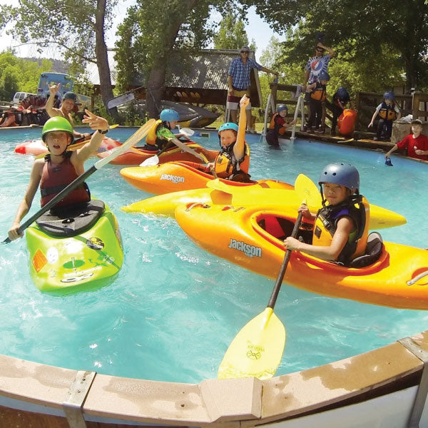 a group of people riding kayaks on top of a pool.
