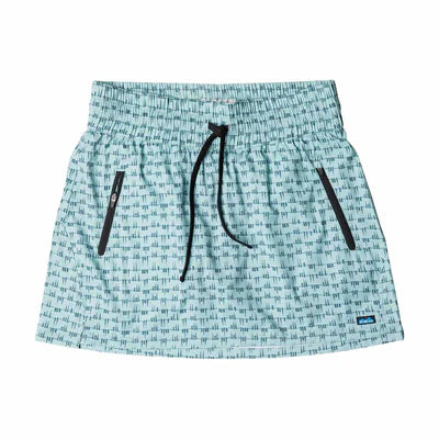 The Kavu Just Beachy Skirt is a light blue patterned recycled polyester skort featuring black zippered pockets, a black drawstring waist, and a small blue logo tag at the bottom right.