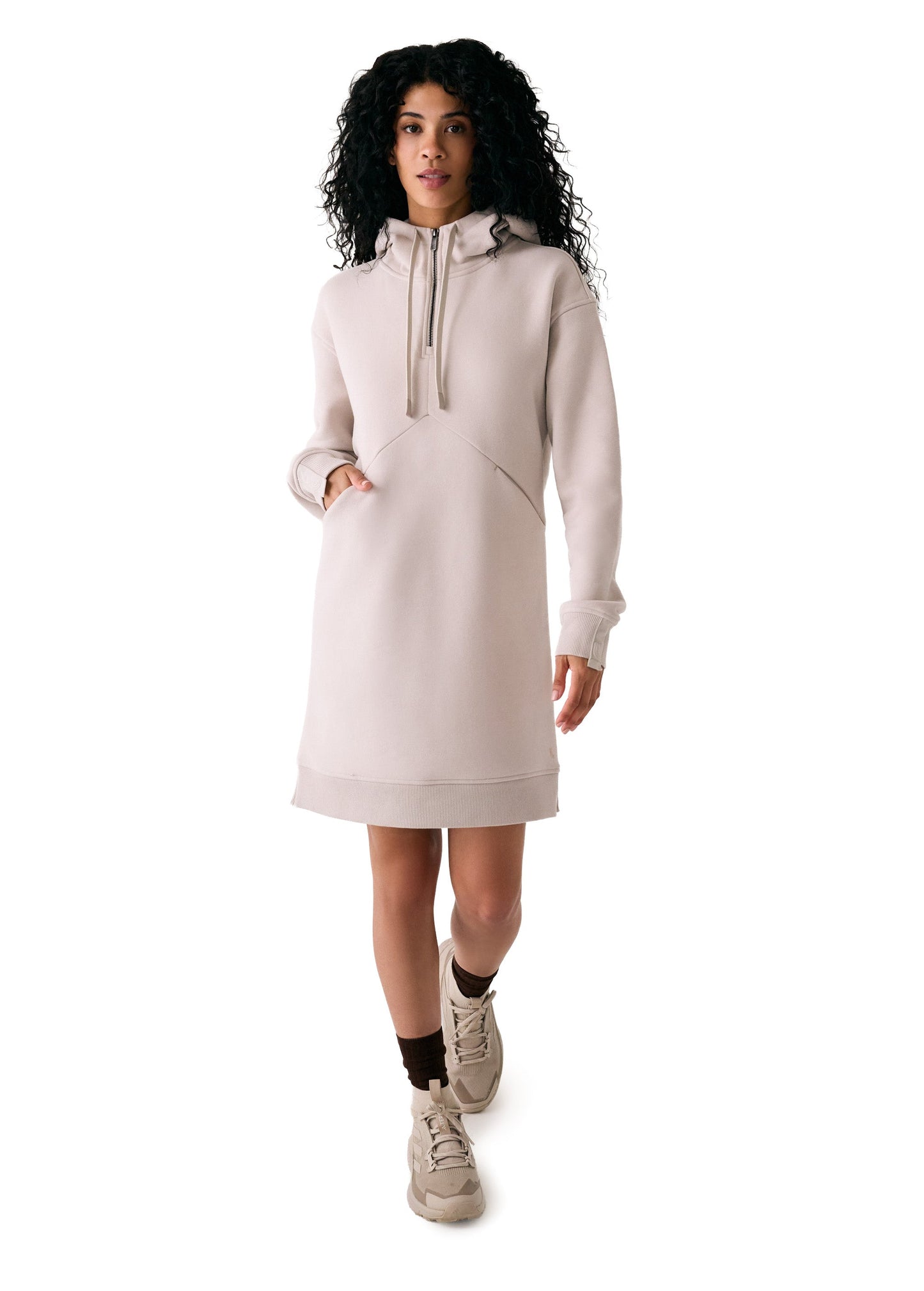 A woman in the Lole Yonder Hoodie Dress, paired with brown socks and beige sneakers, stands against a white background.