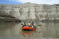 a couple of people in a boat on a body of water.