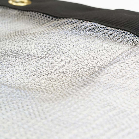Close-up of the Canyon Coolers Stainless Mesh Drag Bag featuring a stainless steel mesh sheet with a black reinforced edge and brass grommet, designed for outdoor adventures.