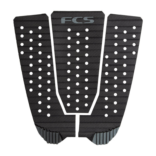 The FCS Kolohe Tread-Lite Traction Pad is a black three-piece pad with nano-dot grip technology, a textured surface, circular holes, diagonal grooves, and an "FCS" logo at the top center.