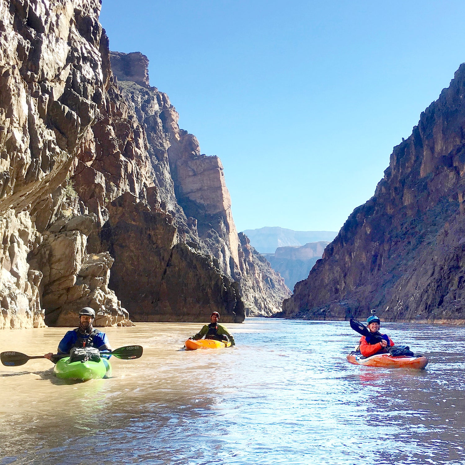 a group of people riding kayaks on top of a river.