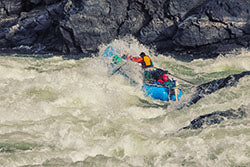 a man riding a raft on top of a river.