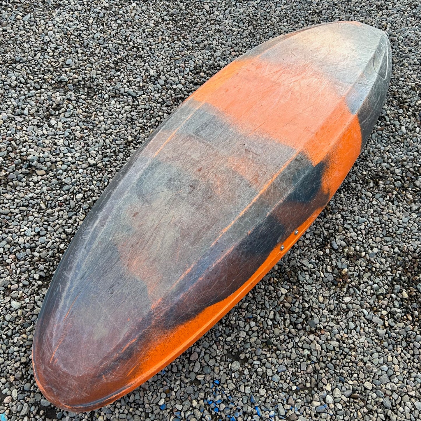 A Pyranha Demo Firecracker 242 canoe laying on the ground.