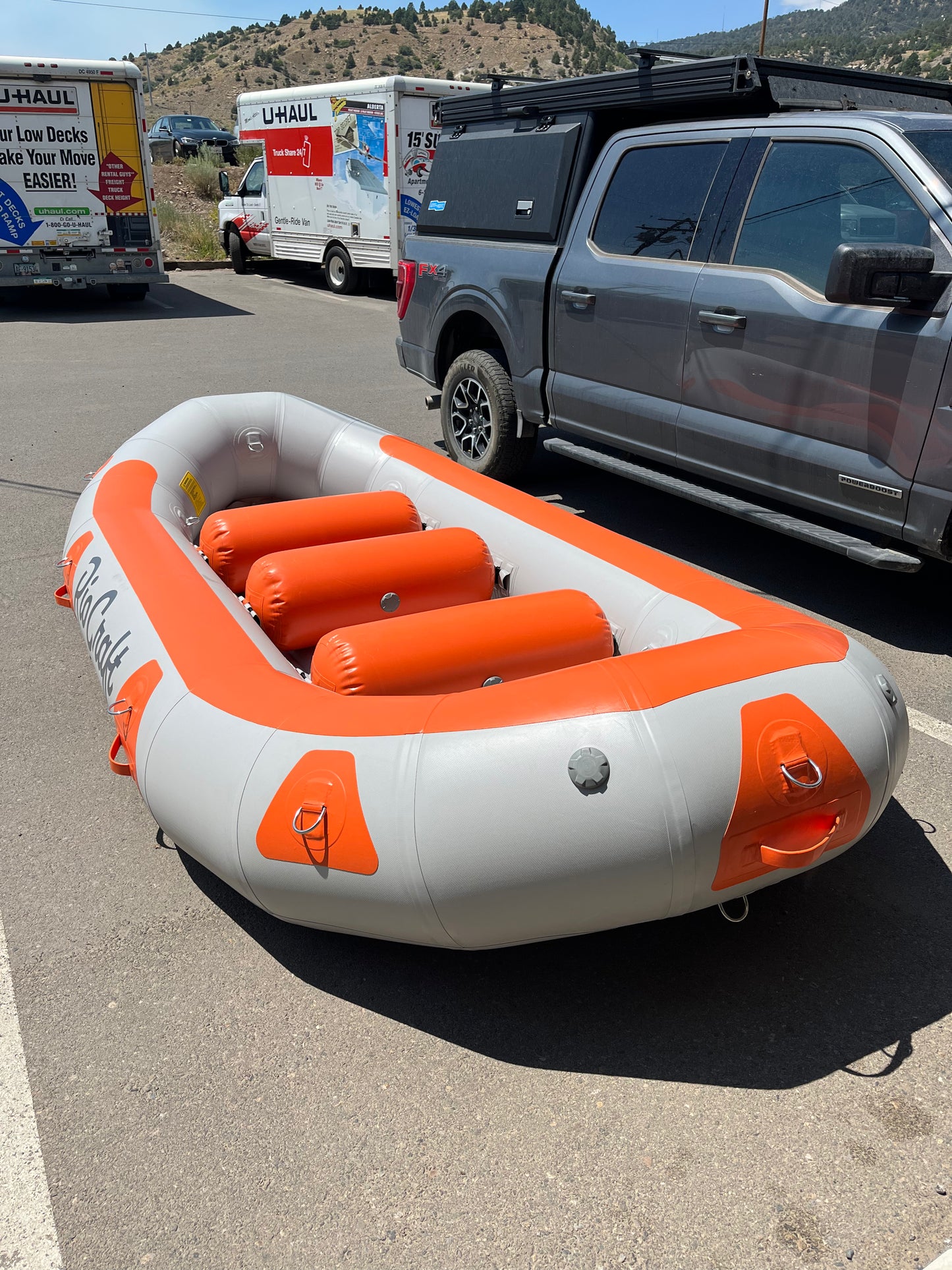A Rio Craft Consignment 13' Colorado raft parked in a parking lot.