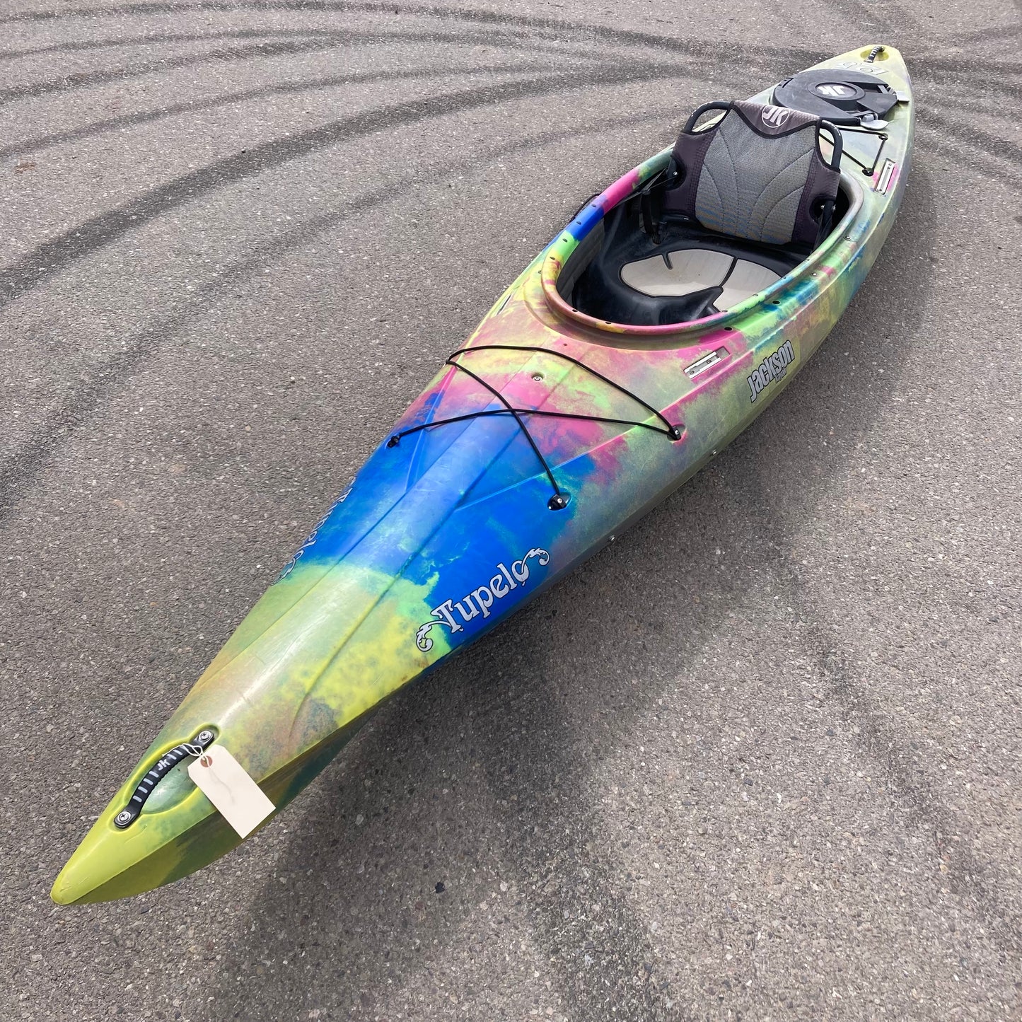 A colorful Demo Tupelo 12.5 kayak from Jackson Kayak is parked on the street.