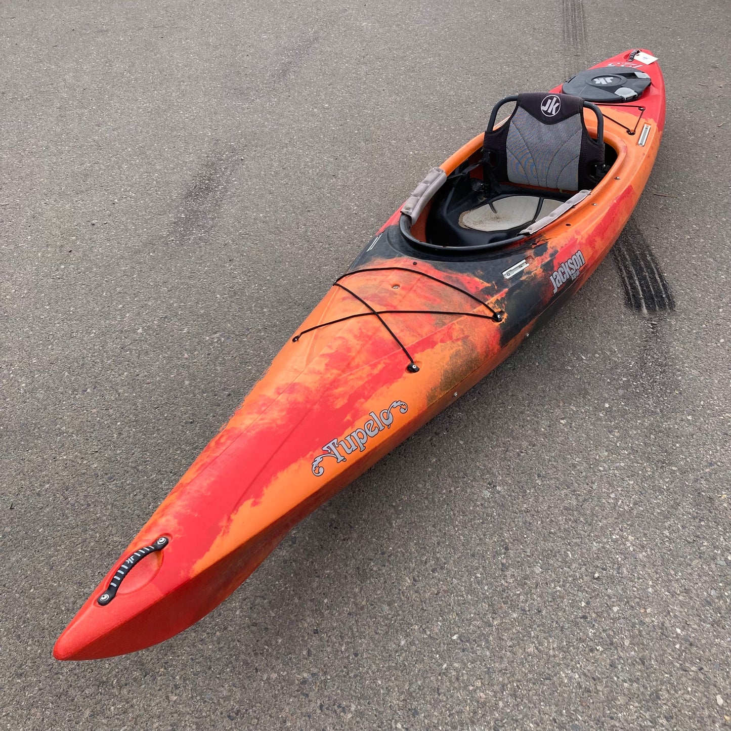 A Demo Tupelo 12.5 kayak by Jackson Kayak is parked on the side of the road.
