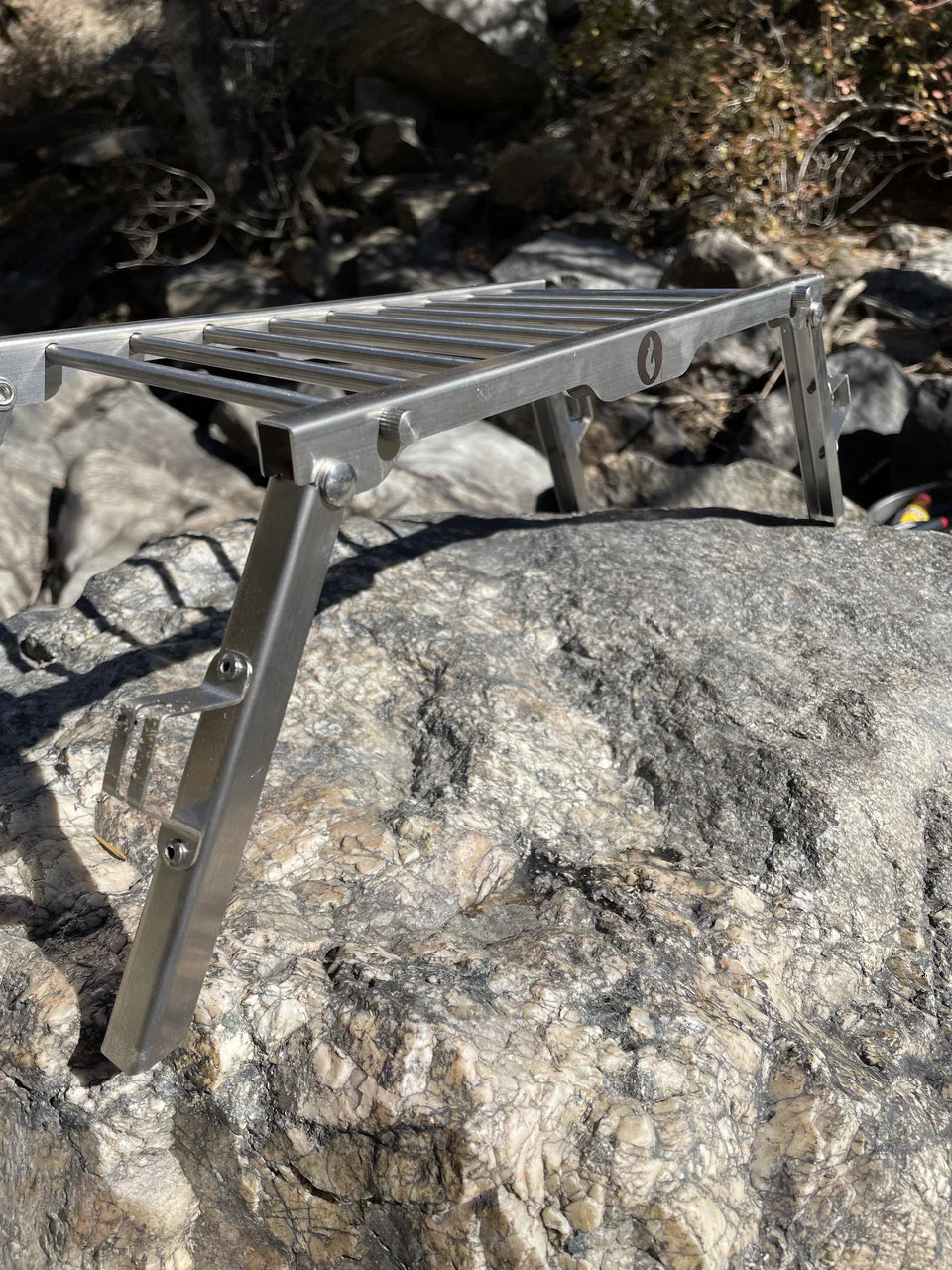 An Over Under Grill Thingy by LavaBox sitting on top of a rock.