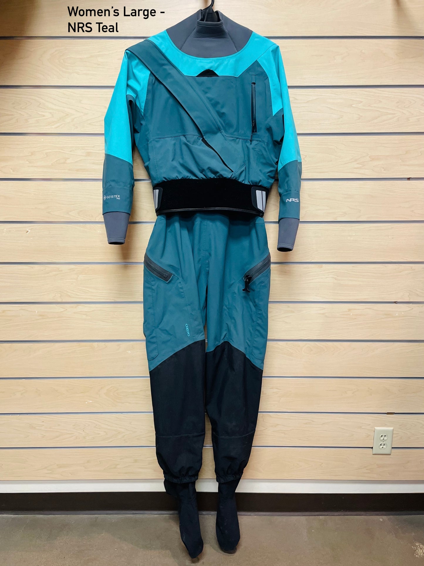 A Rental Dry Suit by 4Corners Riversports hanging on a wall.