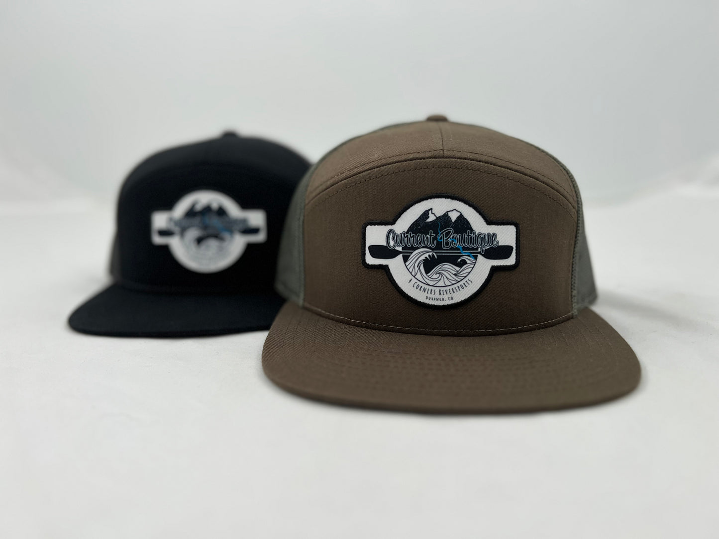 A Captuer Headwear Current Boutique 7 Panel Patch Hat with a logo on it.