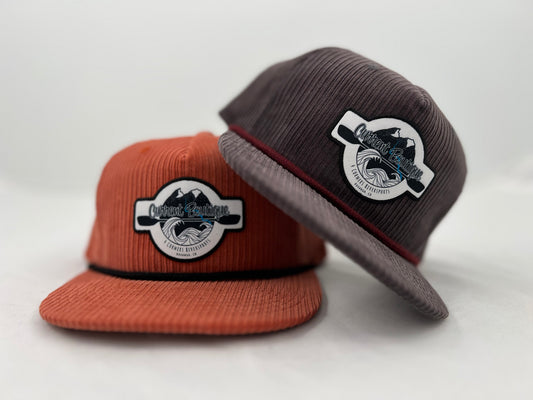 Two Current Boutique Cord Pops Hats with Captuer Headwear circular logo patches displayed against a white background.
