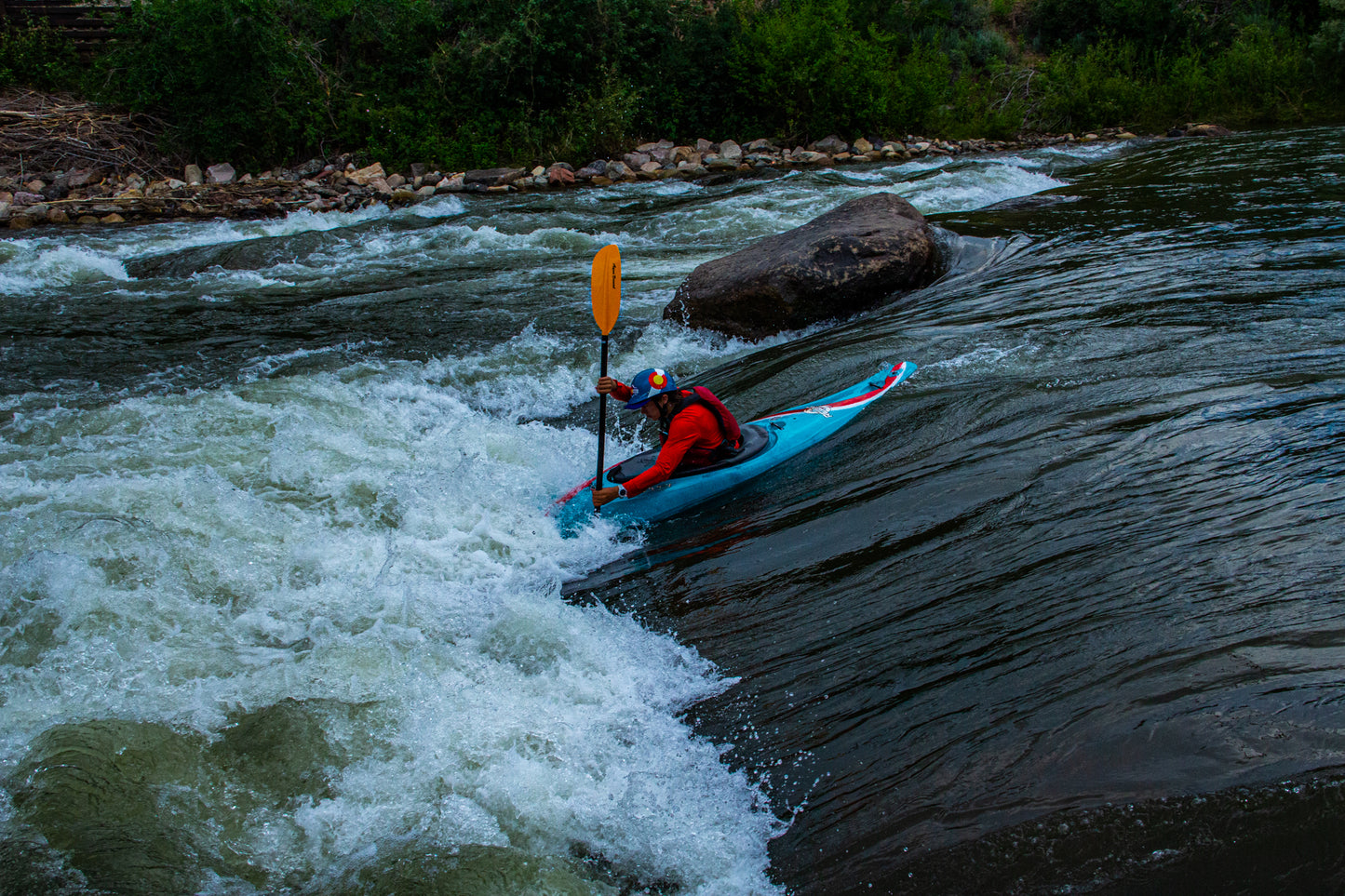 A beginner is taking the Young Adult Level 1 Kayak Class, offered by 4CRS Paddle School, in a river, learning the fundamentals of this water sport.