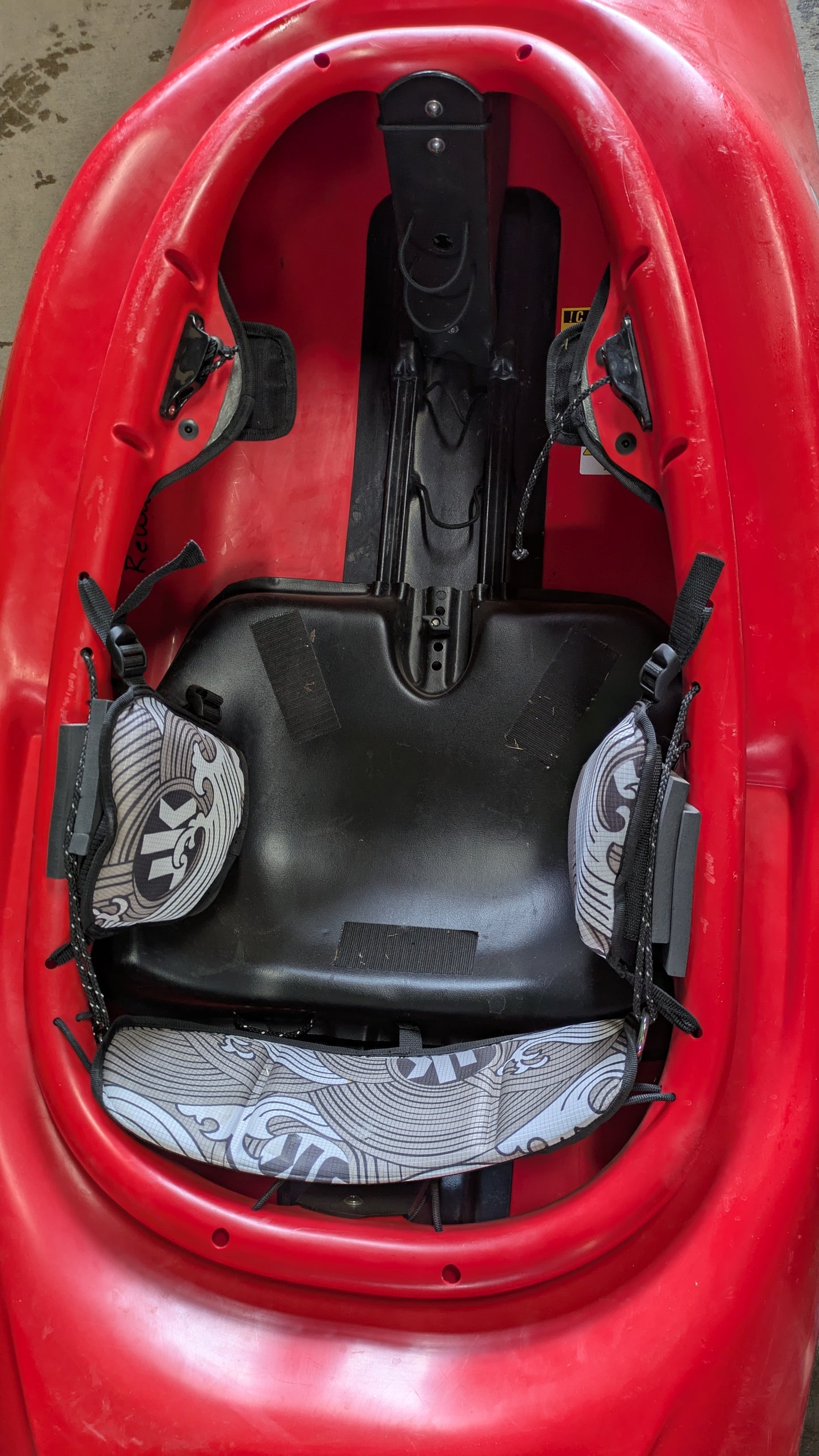 Close-up of the Demo Rockstar V LG by Jackson Kayak, showing its interior seat, backrest, footrest, and adjustable hip pads with gray patterned covers.