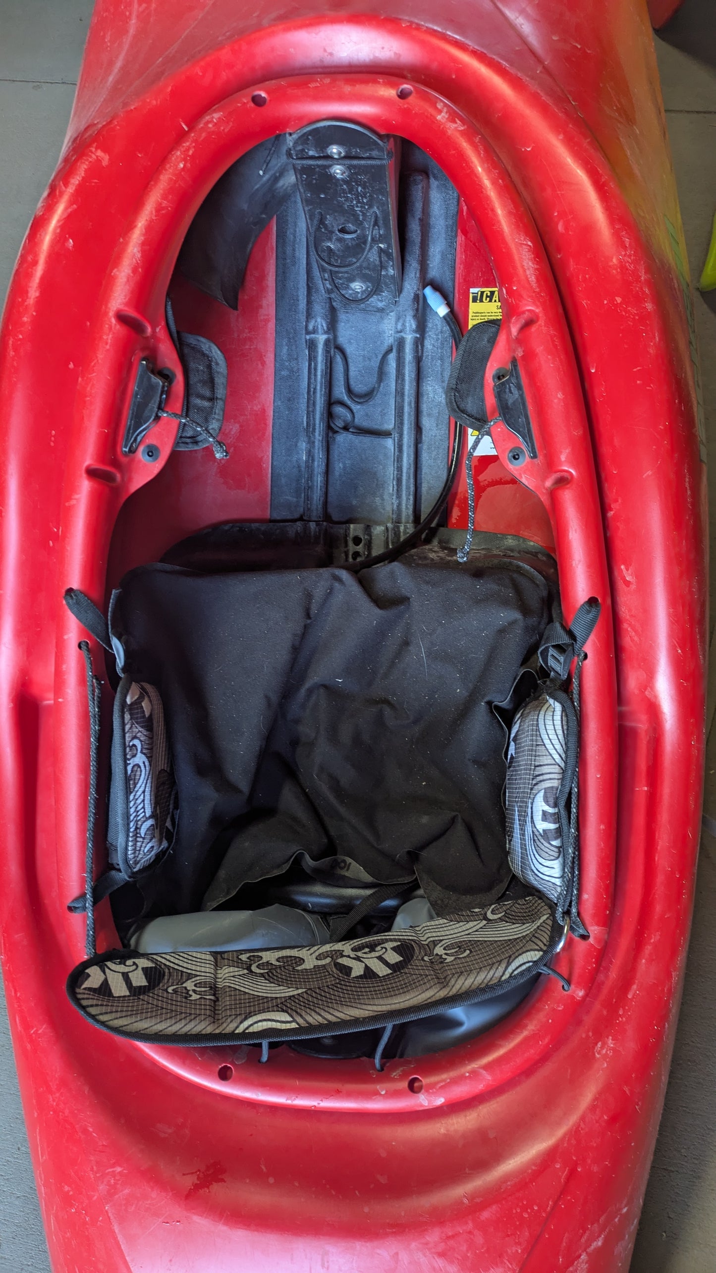 Top-down view of the cockpit of a used Jackson Kayak Demo Rockstar V MD, displaying the seat, foot braces, and padded hip supports.