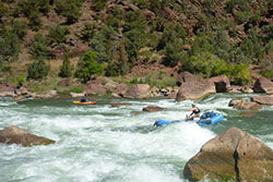 a group of people are rafting down a river.