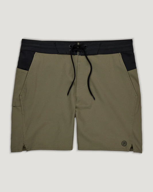 The Men's Pinnacle Utility Boardshort by Free Fly features olive green and black colors, an elastic waistband with black drawstring, front pockets, quick-dry fabric, and a small logo on the left leg.
