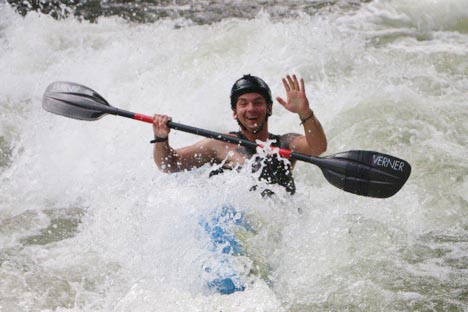 a man riding a paddle board on top of a wave.